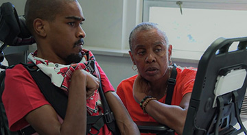 Two people looking at a text-to-speech screen.