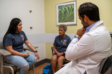 Officer Julia Garcia-Martinez sitting with mother and doctor.